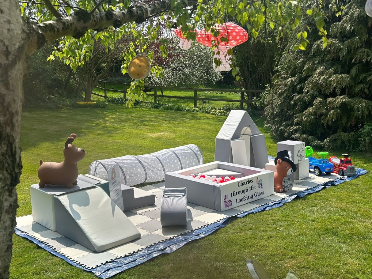 Alice in Wonderland themed soft play setup in a garden setting with whimsical decorations.