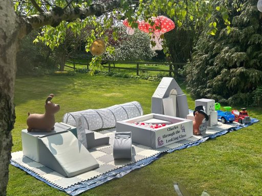 Alice in Wonderland themed soft play setup in a garden setting with whimsical decorations.
