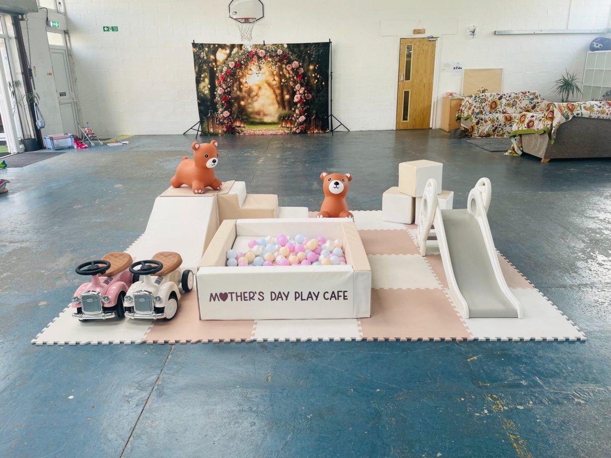 A play area with a slide, ball pit, toy cars, and decorative animal figures.